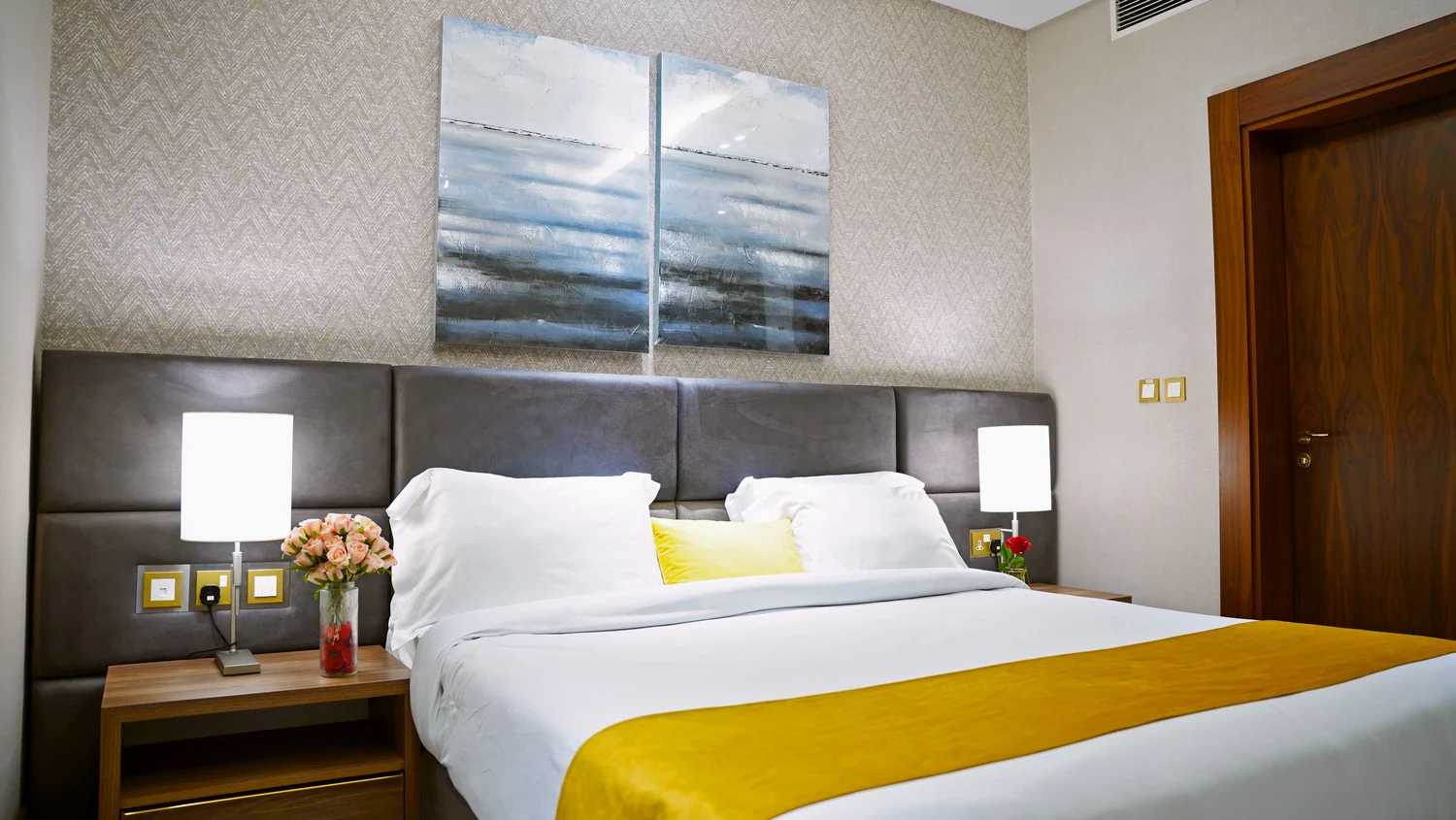 Abraj INN Suites, Doha Hotels: king bed with a grey padded headboard, white linen and a mustard runner