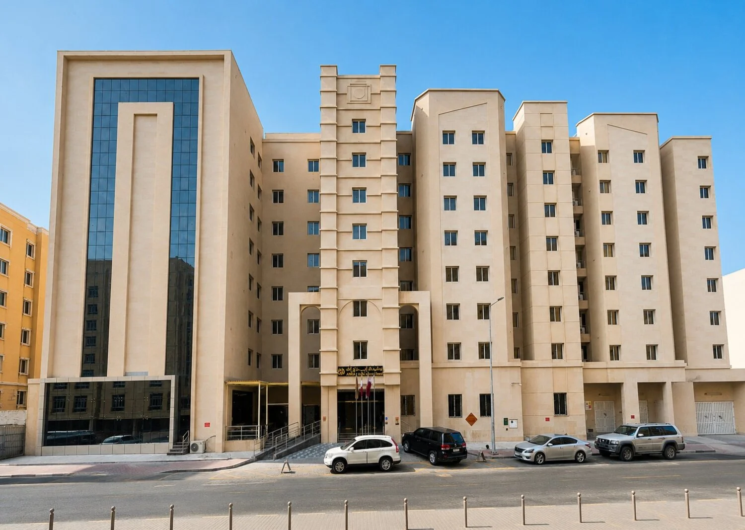 Abraj INN Suites, Doha Hotels: the beige nine-storey building with a dark glass wing and Qatari flags at the entrance