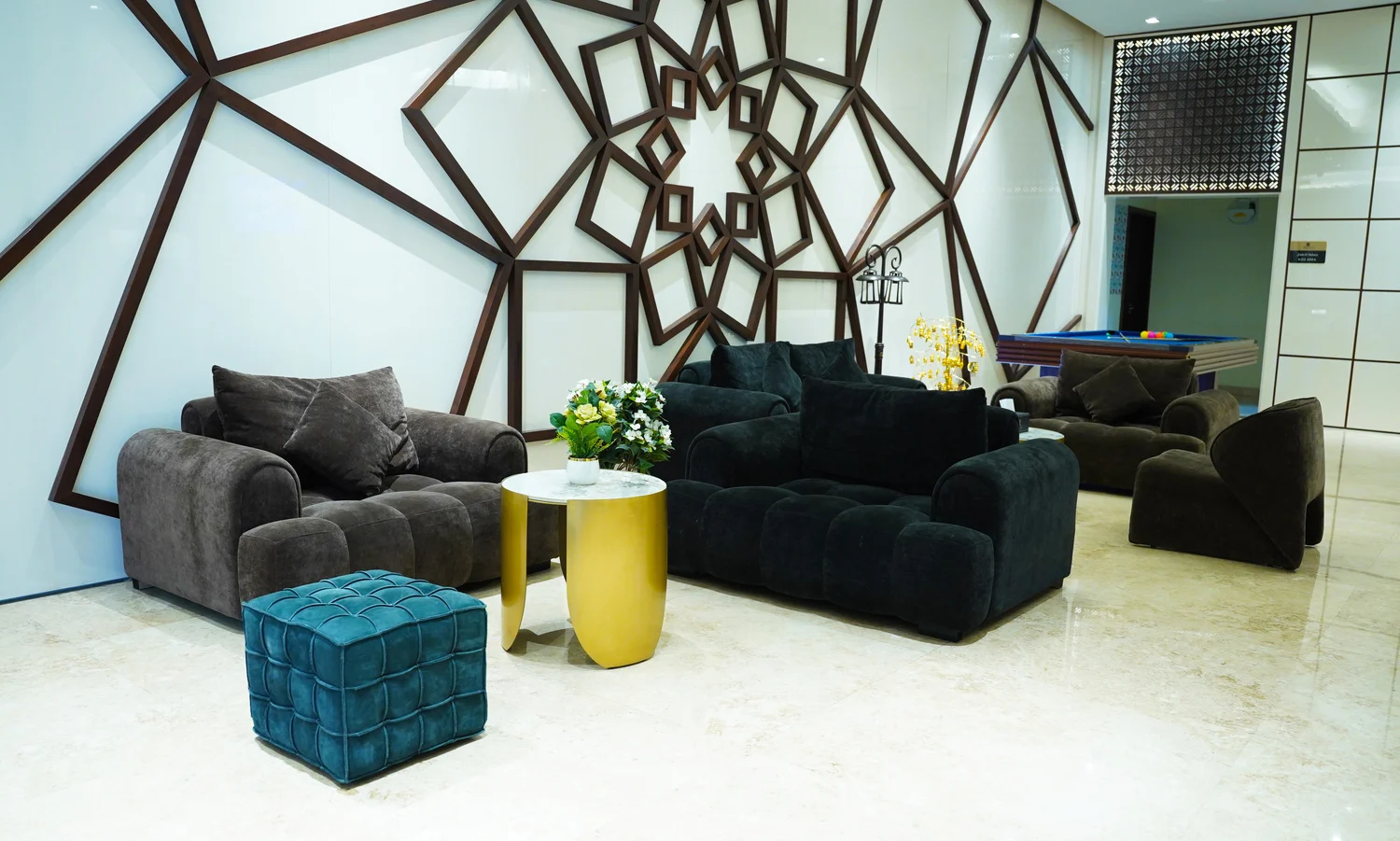 Abraj INN Suites, Doha Hotels: lobby lounge with a black sofa, carved Islamic-pattern wall and a billiard table behind