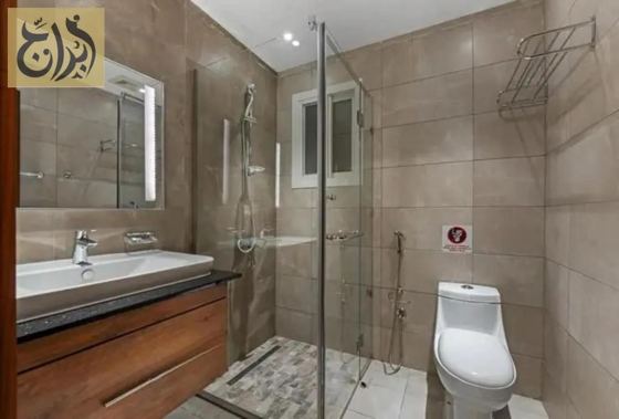 Bathroom with walk in shower and vanity in a one-bedroom suite at Abraj Suites Hotel Doha