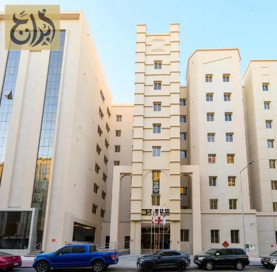 Exterior street view of the Abraj Suites Hotel building on Hisham Bin Oqba Street, Al Mansoura, Doha