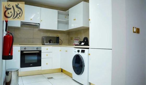 Western style kitchen with oven, fridge and washing machine in a suite at Abraj Suites Hotel Doha