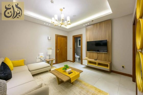 Separate living room with smart television in a furnished apartment at Abraj Suites Hotel Doha