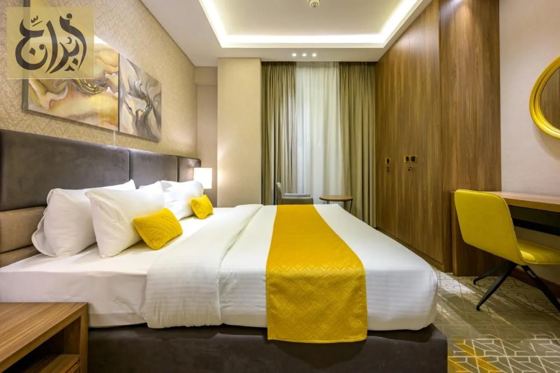 Bedroom with king bed and work desk in a long stay apartment at Abraj Suites Hotel Doha