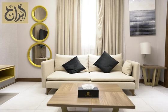 Living room with dining table in a one-bedroom apartment at Abraj Suites Hotel Doha