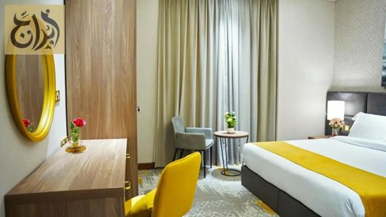 Suite bedroom with dressing desk and chair at Abraj Suites Hotel Doha