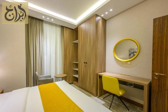 Suite bedroom with wardrobe and work desk at Abraj Suites Hotel Doha